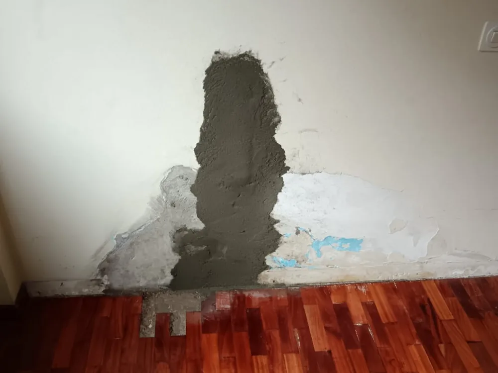 Base de una pared con la roza cerrada tras localizar el origen de la humedad