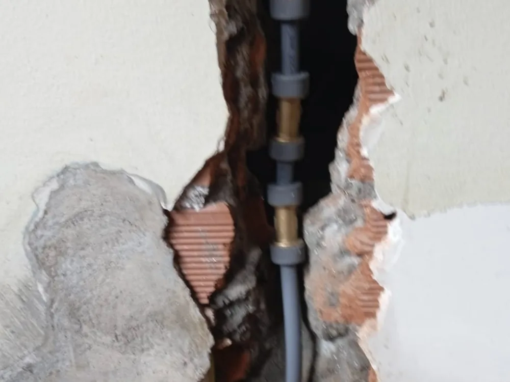 Roza abierta en la pared con la tubería antigua sustituida por material nuevo