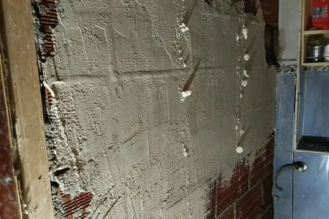 Pared con las rozas de la nueva instalación de agua ya cerradas con mortero
