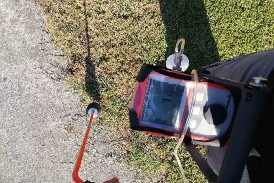 Sonda y detector de gas trazador localizando una fuga bajo el pavimento