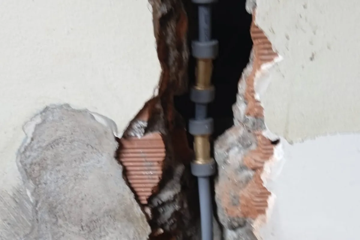 Tubería reparada dentro de una roza abierta en la pared de una vivienda